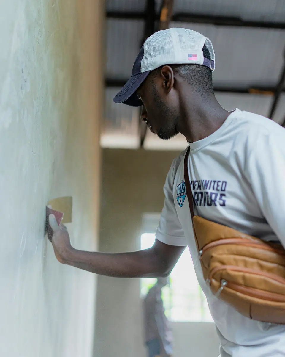 A tradesman filling a crack in a plastered wall
