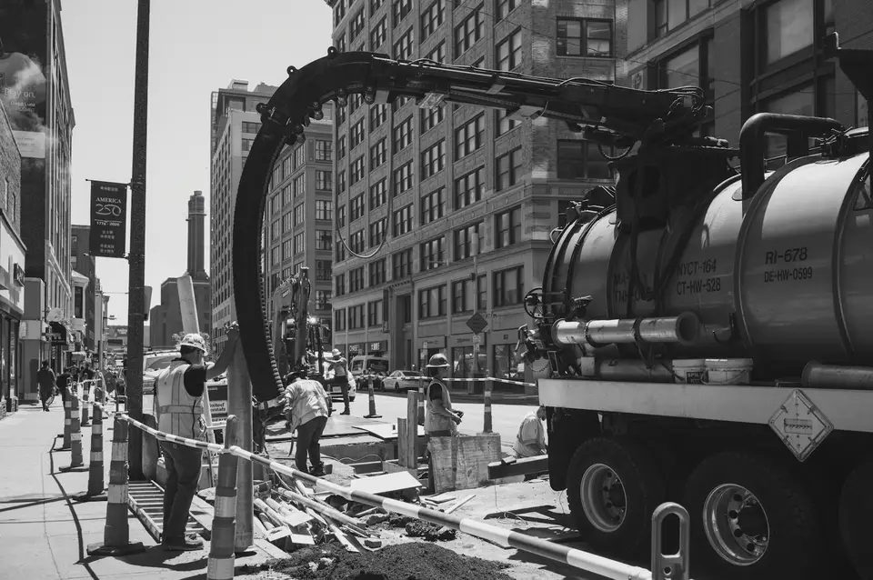A vacuum tanker parked beside street drainage works
