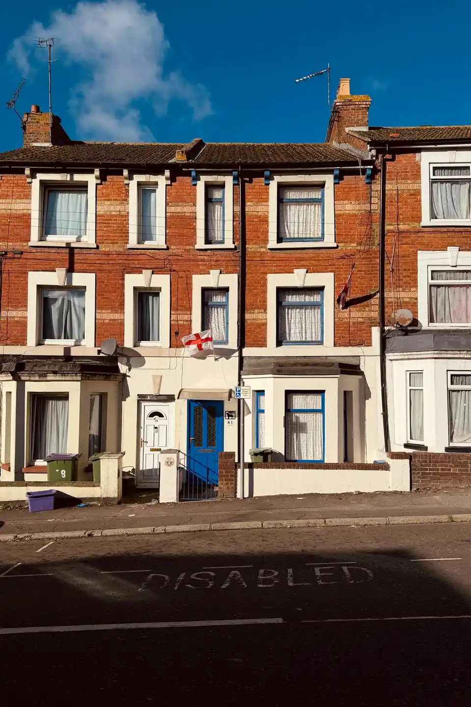 A row of brick terraced houses with painted doors